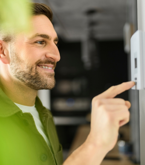 man adjusting his thermostat